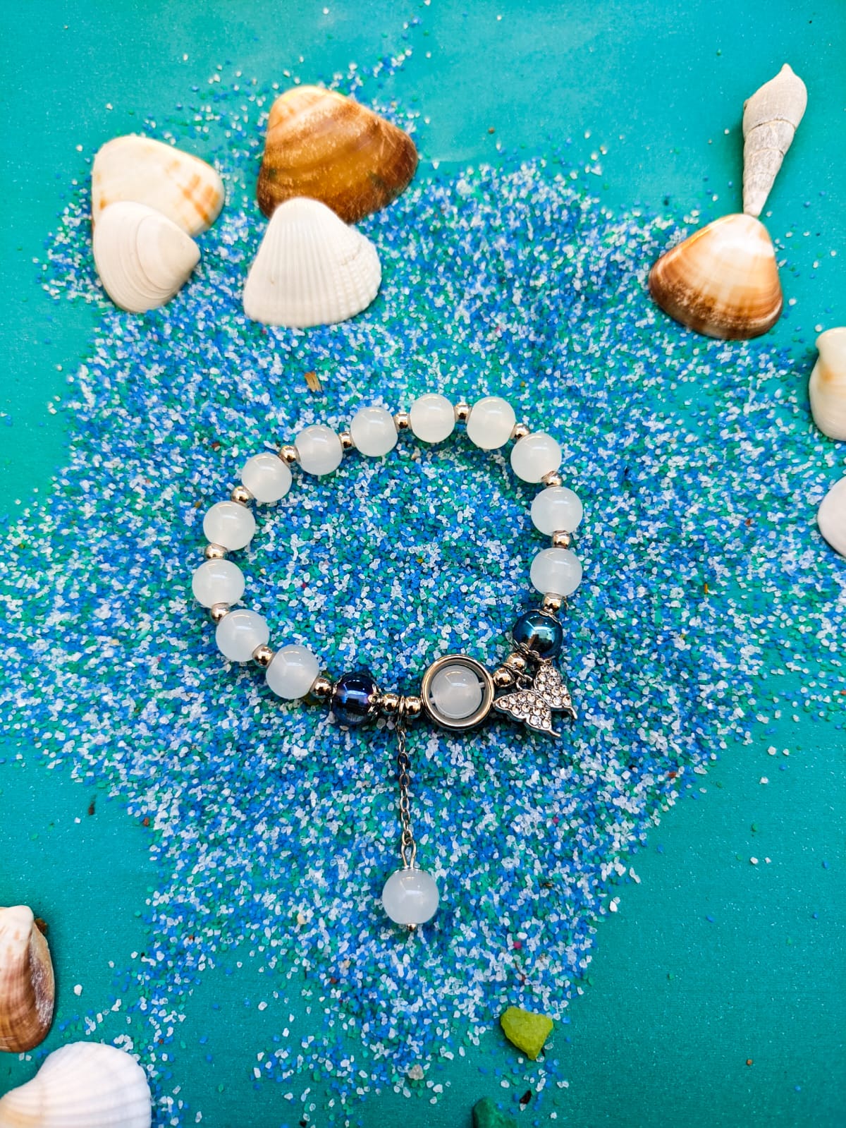 Um acessório cheio de charme, com pedras naturais claras e detalhes metálicos que lembram o brilho do sol e o movimento das ondas. Perfeita para quem ama o estilo praiano e quer levar um pedacinho do mar para o dia a dia. 🦋✨